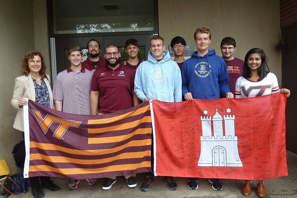 Group of students with professor holding university flags